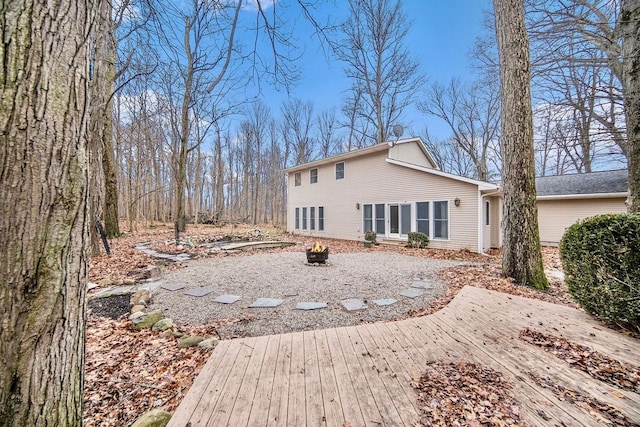 back of house featuring a fire pit and a deck