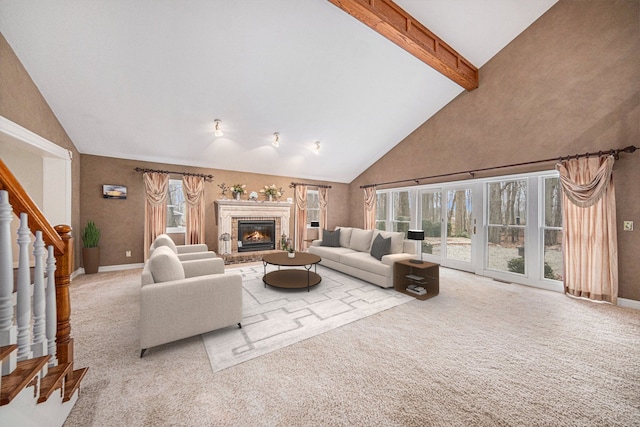 living room featuring a fireplace, beam ceiling, high vaulted ceiling, and light carpet