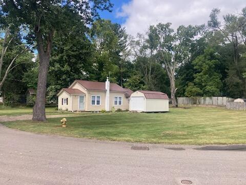 view of front of home with a storage unit and a front yard