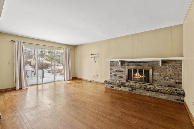 unfurnished living room featuring a fireplace and light hardwood / wood-style floors