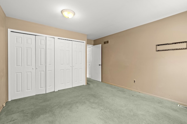 unfurnished bedroom featuring multiple closets and carpet flooring