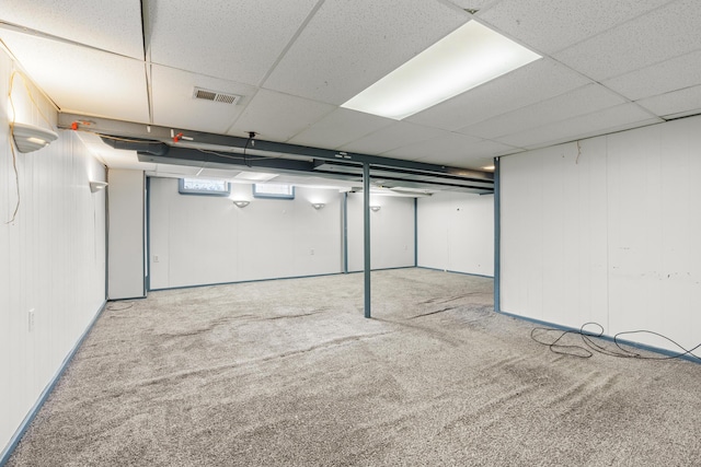 basement with light carpet and a drop ceiling