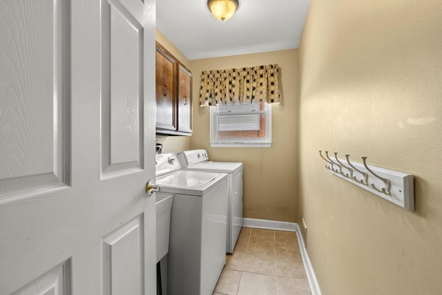 washroom featuring cabinets, light tile patterned floors, and washing machine and clothes dryer