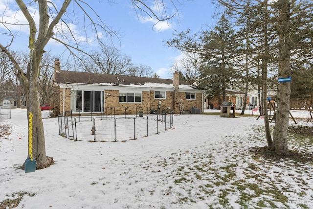 snow covered back of property featuring cooling unit