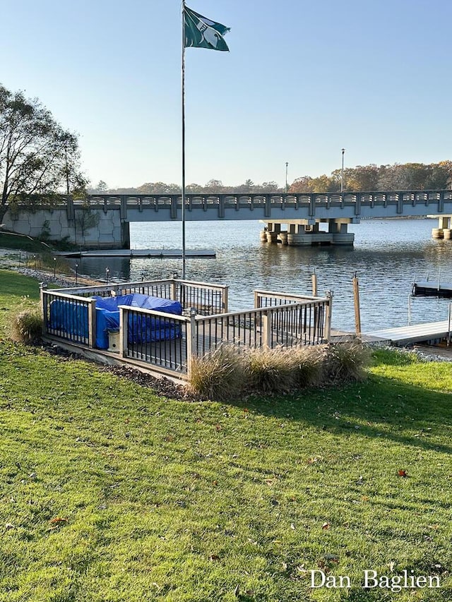 dock area with a water view and a lawn