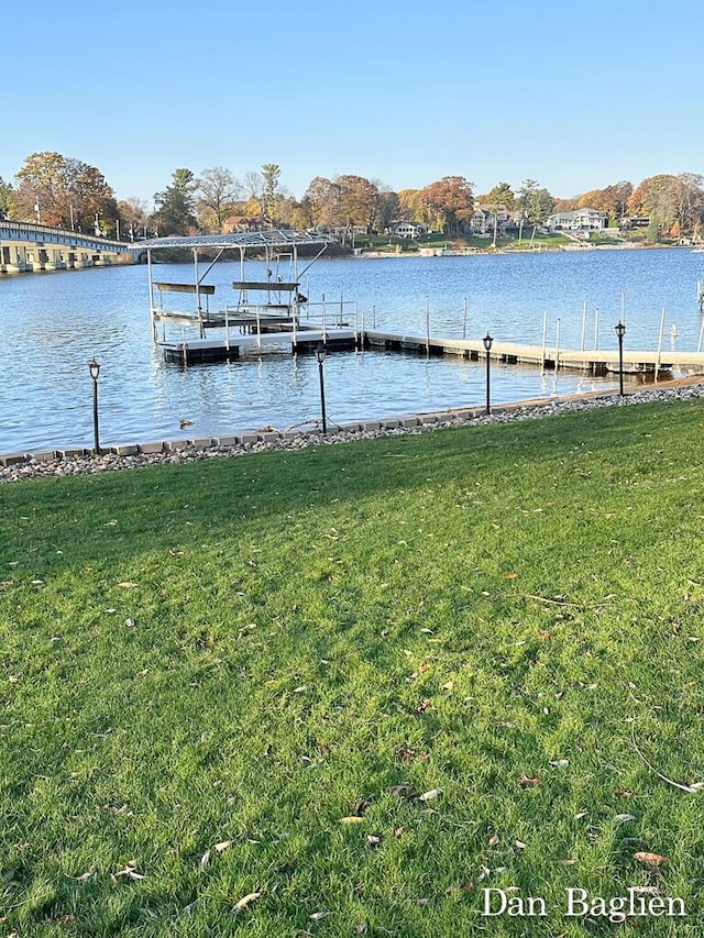 dock area featuring a water view and a lawn