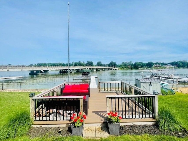 dock area featuring a deck with water view and a yard