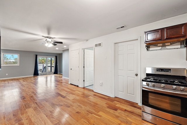 kitchen with dark brown cabinetry, stainless steel range with gas cooktop, light hardwood / wood-style floors, and ceiling fan