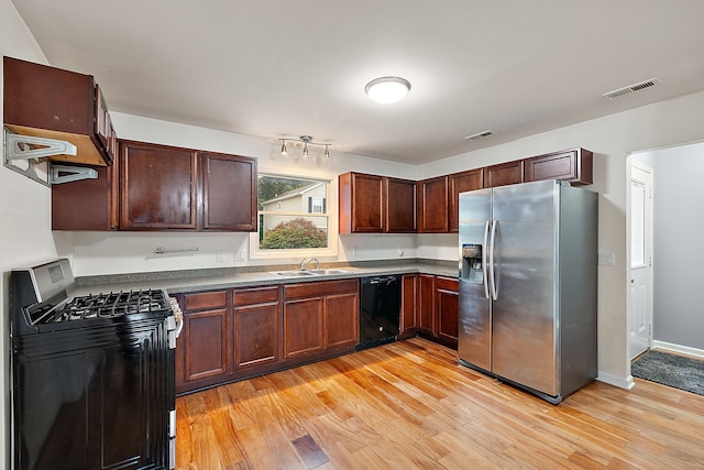 kitchen with stainless steel appliances, sink, and light wood-type flooring