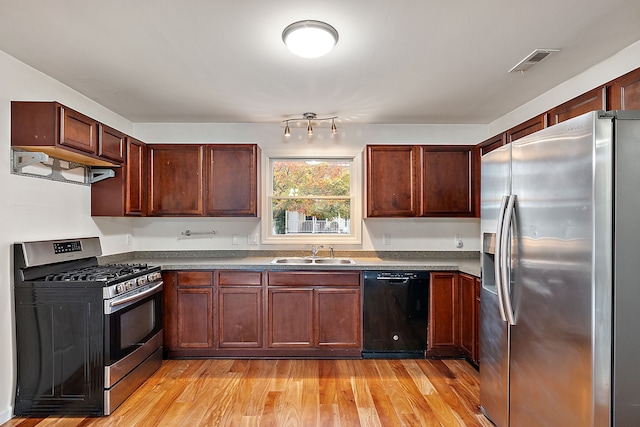 kitchen featuring extractor fan, stainless steel appliances, light hardwood / wood-style floors, and sink