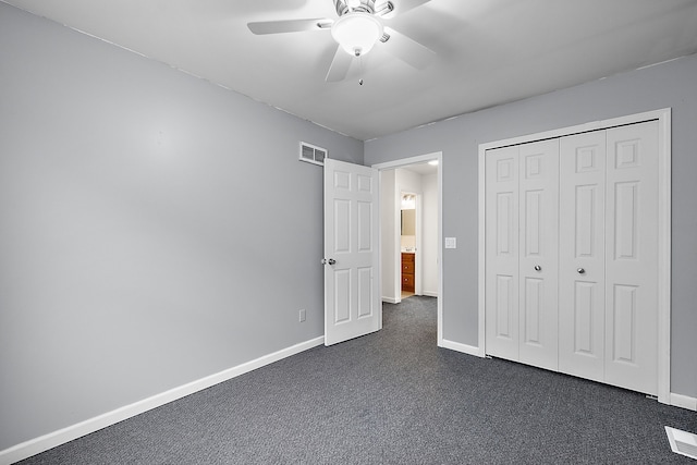 unfurnished bedroom featuring ceiling fan, dark carpet, and a closet