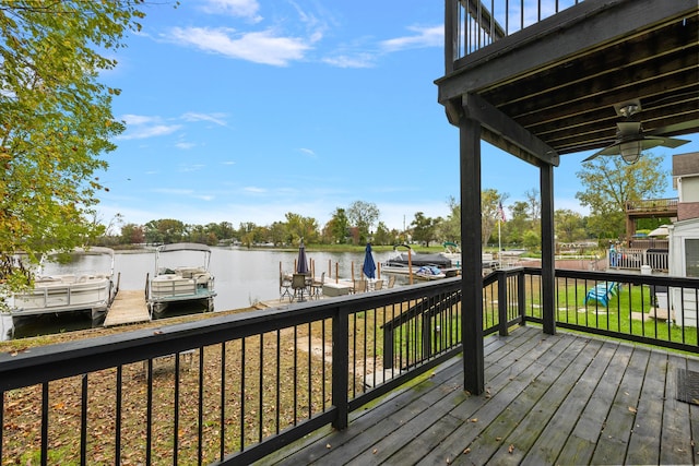 wooden terrace featuring a water view, ceiling fan, and a boat dock