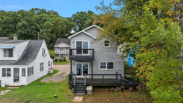 back of house featuring a wooden deck, a balcony, and a yard