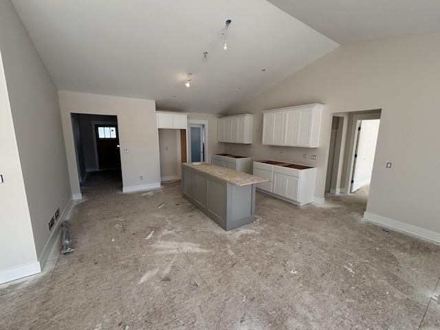 kitchen featuring a large island, washer / dryer, high vaulted ceiling, and white cabinets