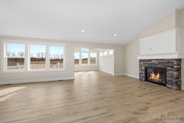 3432 Conrail Dr, Byron Center, MI 49315 - unfurnished living room featuring a fireplace, light wood finished floors, lofted ceiling, baseboards, and recessed lighting