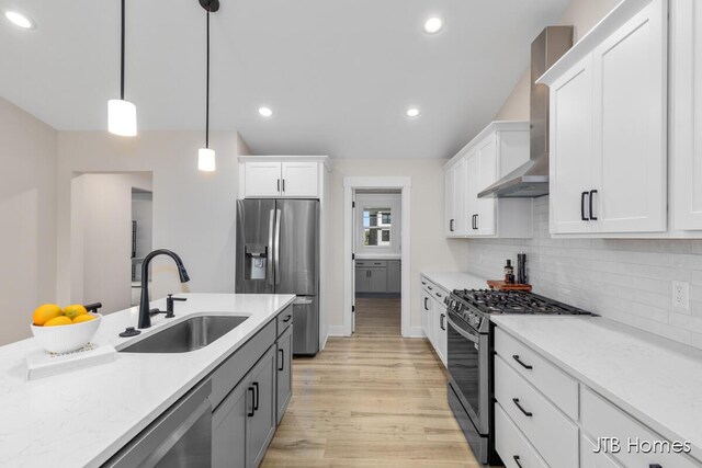 3432 Conrail Dr, Byron Center, MI 49315 - kitchen with stainless steel appliances, a sink, wall chimney exhaust hood, light wood-type flooring, and light countertops