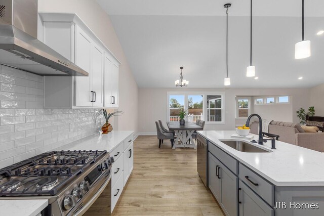 3432 Conrail Dr, Byron Center, MI 49315 - kitchen featuring wall chimney exhaust hood, stainless steel appliances, a sink, gray cabinetry, and light wood-style floors
