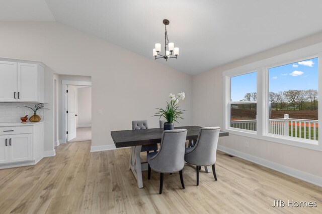 3432 Conrail Dr, Byron Center, MI 49315 - dining space featuring vaulted ceiling, a chandelier, light wood-style floors, and baseboards