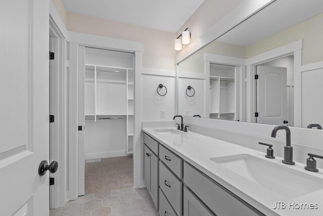 3432 Conrail Dr, Byron Center, MI 49315 - bathroom featuring a walk in closet, double vanity, and tile patterned flooring