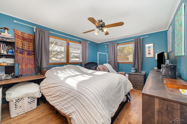 bedroom with crown molding, ceiling fan, and light hardwood / wood-style flooring