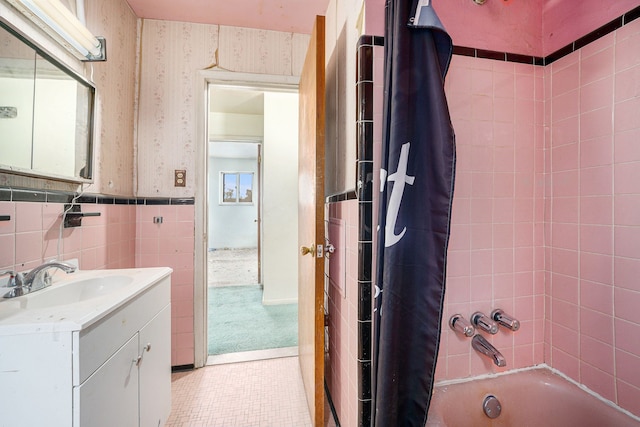 bathroom with vanity, shower / bath combo with shower curtain, and tile walls