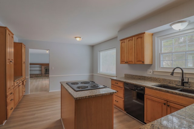 kitchen with sink, light hardwood / wood-style flooring, black appliances, and a kitchen island