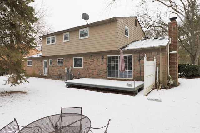 snow covered rear of property with cooling unit