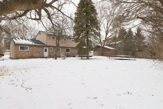 snow covered property with a trampoline