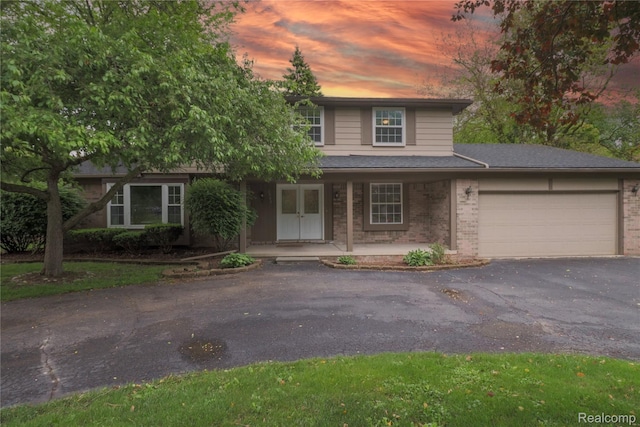6868 Vachon Dr, Bloomfield Hills, MI 48301 - view of front of property featuring brick siding, a garage, driveway, and covered porch