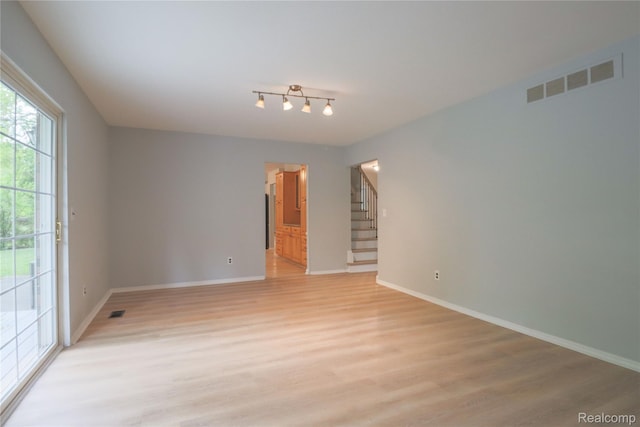 6868 Vachon Dr, Bloomfield Hills, MI 48301 - unfurnished room with light wood-style flooring, stairway, and baseboards