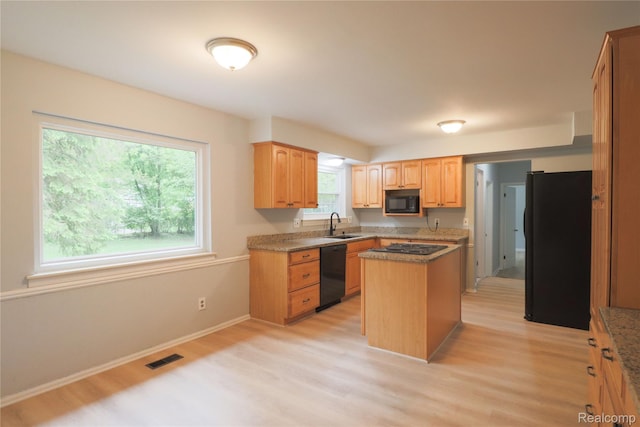 6868 Vachon Dr, Bloomfield Hills, MI 48301 - kitchen with black appliances, a sink, light wood-style flooring, a center island, and baseboards