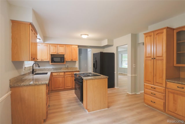 6868 Vachon Dr, Bloomfield Hills, MI 48301 - kitchen with black appliances, a sink, light wood-type flooring, a kitchen island, and light stone counters