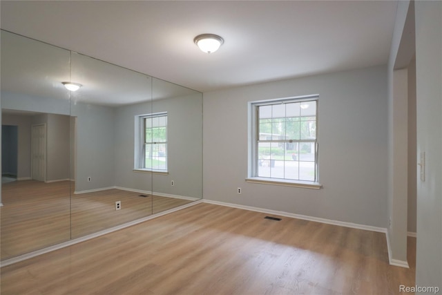 6868 Vachon Dr, Bloomfield Hills, MI 48301 - unfurnished bedroom with light wood-style flooring, baseboards, and a closet