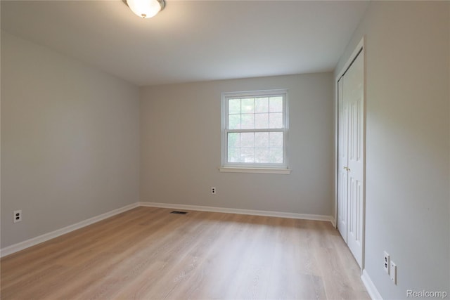 6868 Vachon Dr, Bloomfield Hills, MI 48301 - unfurnished bedroom with light wood-style floors, a closet, and baseboards
