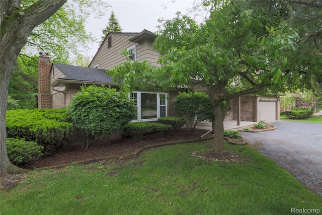 6868 Vachon Dr, Bloomfield Hills, MI 48301 - view of property hidden behind natural elements with driveway, a chimney, brick siding, and a detached garage