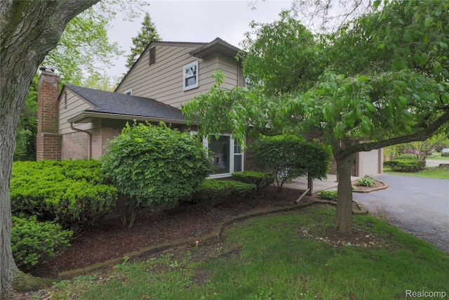6868 Vachon Dr, Bloomfield Hills, MI 48301 - obstructed view of property featuring a chimney, driveway, a garage, and a shingled roof
