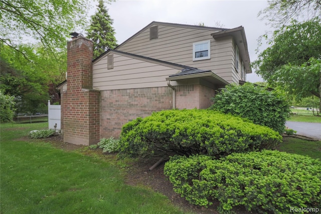 6868 Vachon Dr, Bloomfield Hills, MI 48301 - view of home's exterior featuring a chimney and brick siding