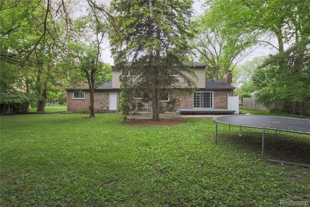6868 Vachon Dr, Bloomfield Hills, MI 48301 - rear view of house featuring a trampoline, a chimney, and brick siding