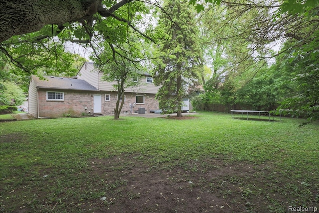 6868 Vachon Dr, Bloomfield Hills, MI 48301 - view of grassy yard with a trampoline