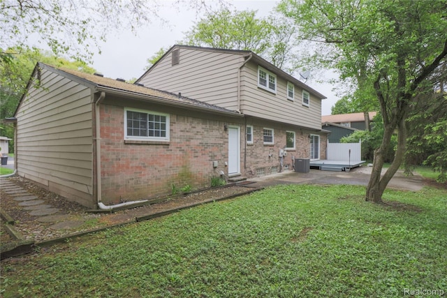 6868 Vachon Dr, Bloomfield Hills, MI 48301 - rear view of house with brick siding, cooling unit, a lawn, and a patio area