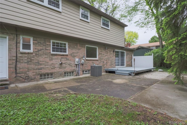 6868 Vachon Dr, Bloomfield Hills, MI 48301 - rear view of house featuring a patio, central air condition unit, a wooden deck, and brick siding
