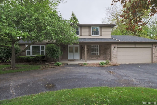 6868 Vachon Dr, Bloomfield Hills, MI 48301 - traditional-style house featuring brick siding, an attached garage, asphalt driveway, a porch, and a shingled roof