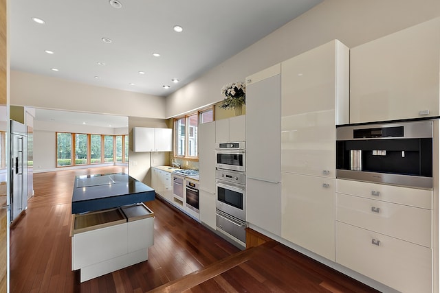 kitchen with white cabinetry, appliances with stainless steel finishes, and dark hardwood / wood-style flooring