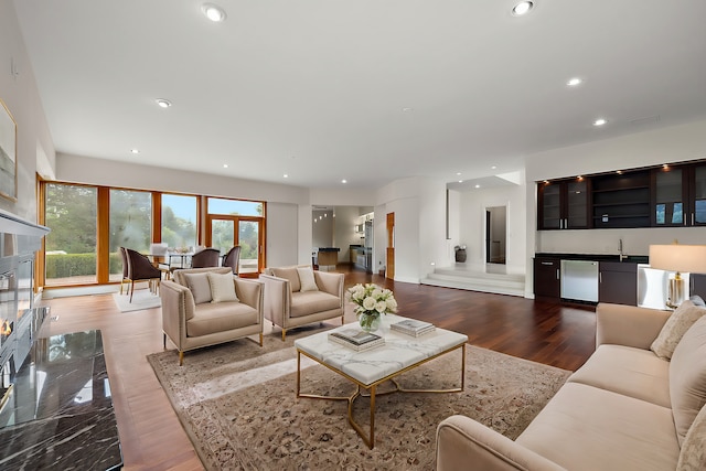 living room with dark hardwood / wood-style flooring and indoor bar