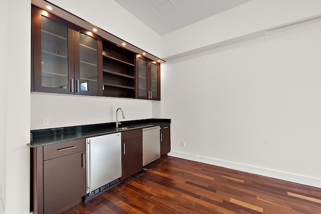 kitchen featuring dark brown cabinetry, appliances with stainless steel finishes, dark hardwood / wood-style flooring, and sink