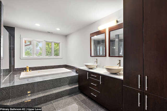 bathroom featuring vanity and tiled tub