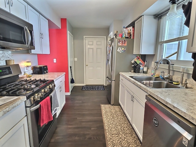 kitchen with white cabinetry, stainless steel appliances, dark hardwood / wood-style flooring, and sink