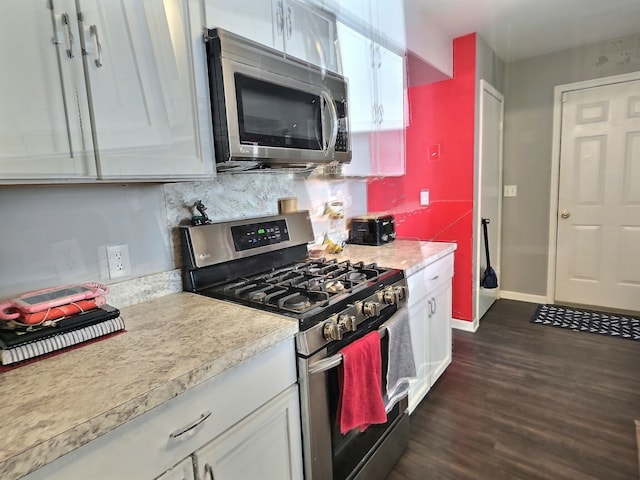 kitchen with stainless steel appliances, dark hardwood / wood-style floors, and white cabinets