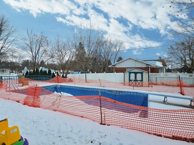 snow covered pool featuring a shed