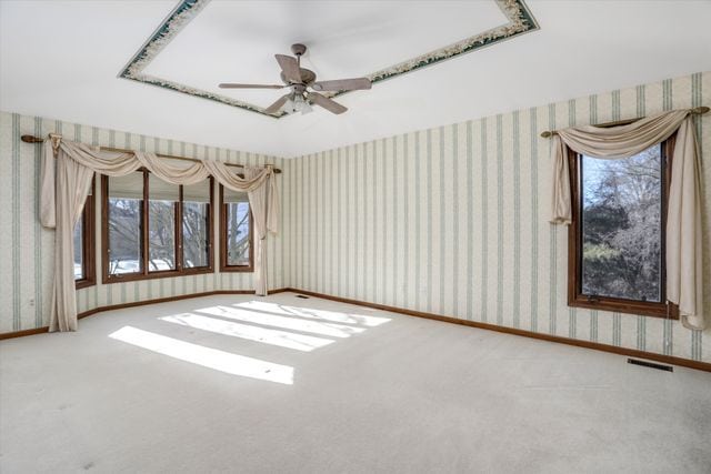 empty room featuring ceiling fan and carpet